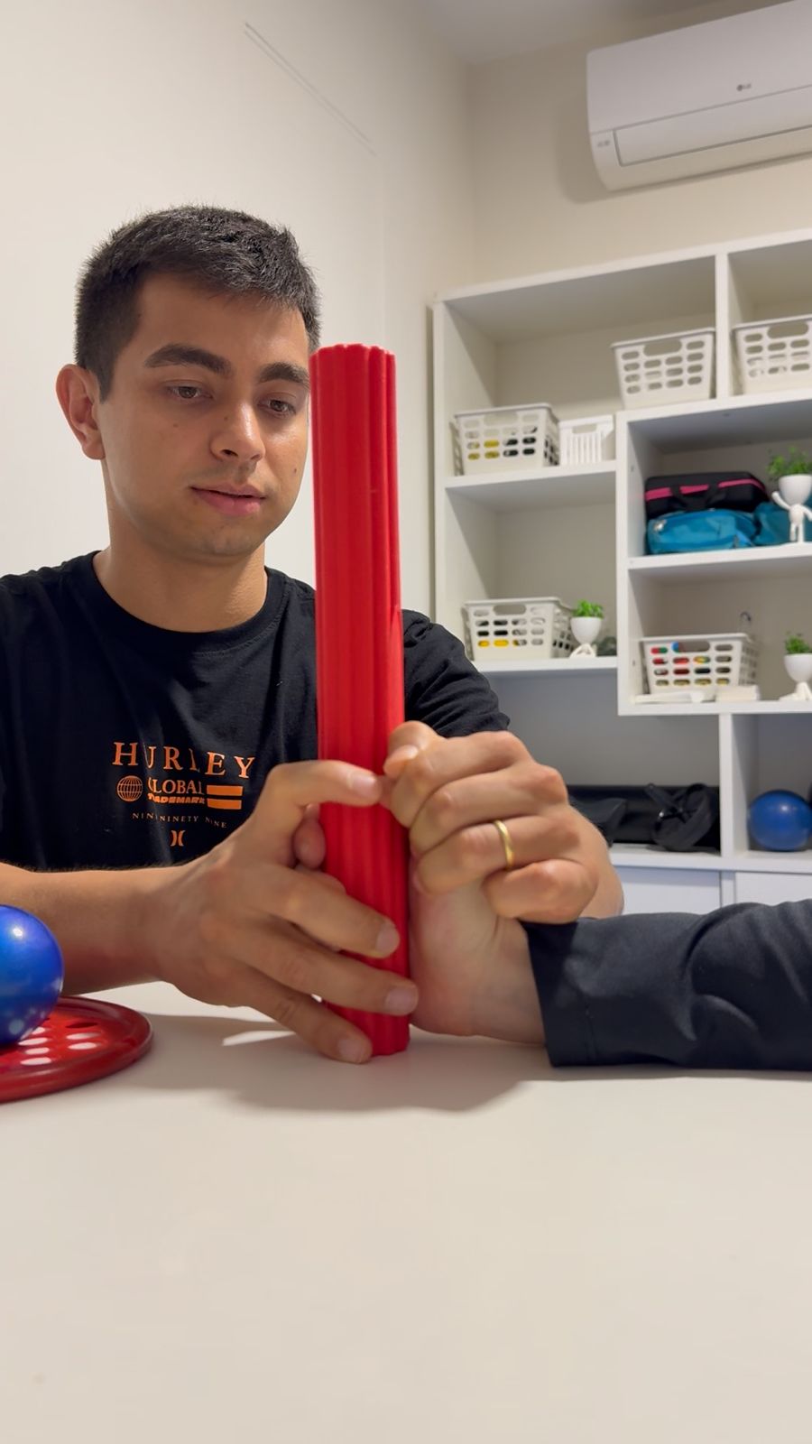 Fabrício aplicando técnica de reabilitação com cilindro terapêutico em membro superior